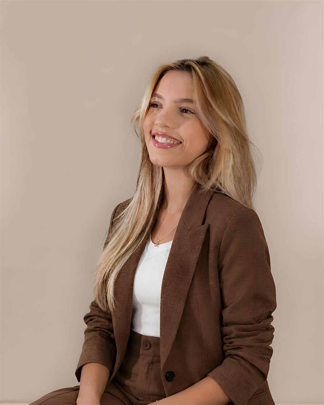 Gabriela Basso sorrindo, de blazer marrom